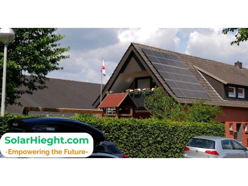 An image of solar panels on a rooftop in a neigbourhood with clear sky and green enviroment